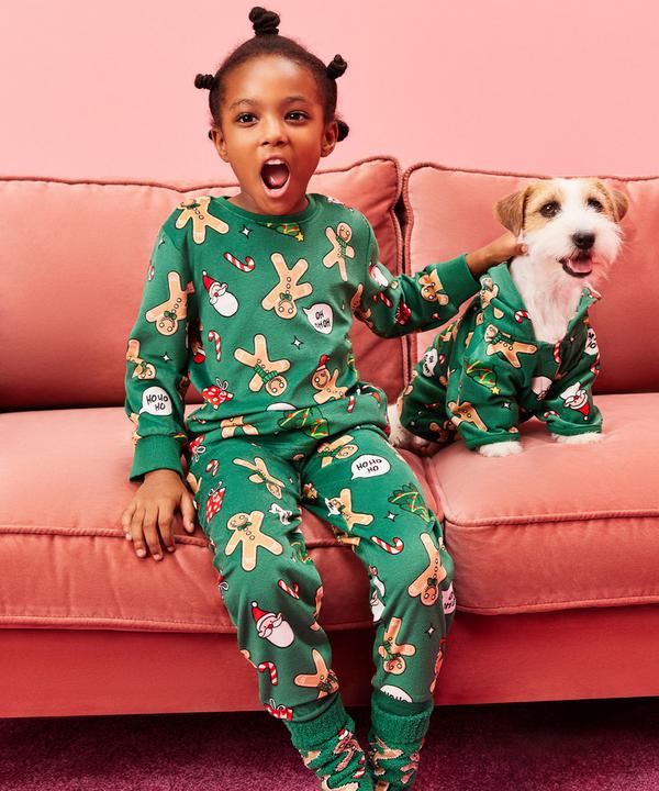 Kind en hond in matchende kerstpyjama's