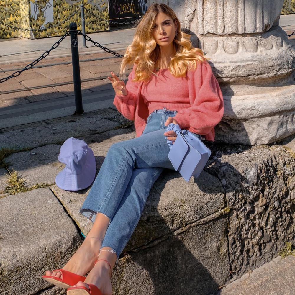 Frau mit rosa Oberteil und blauen Straight-Cut-Jeans