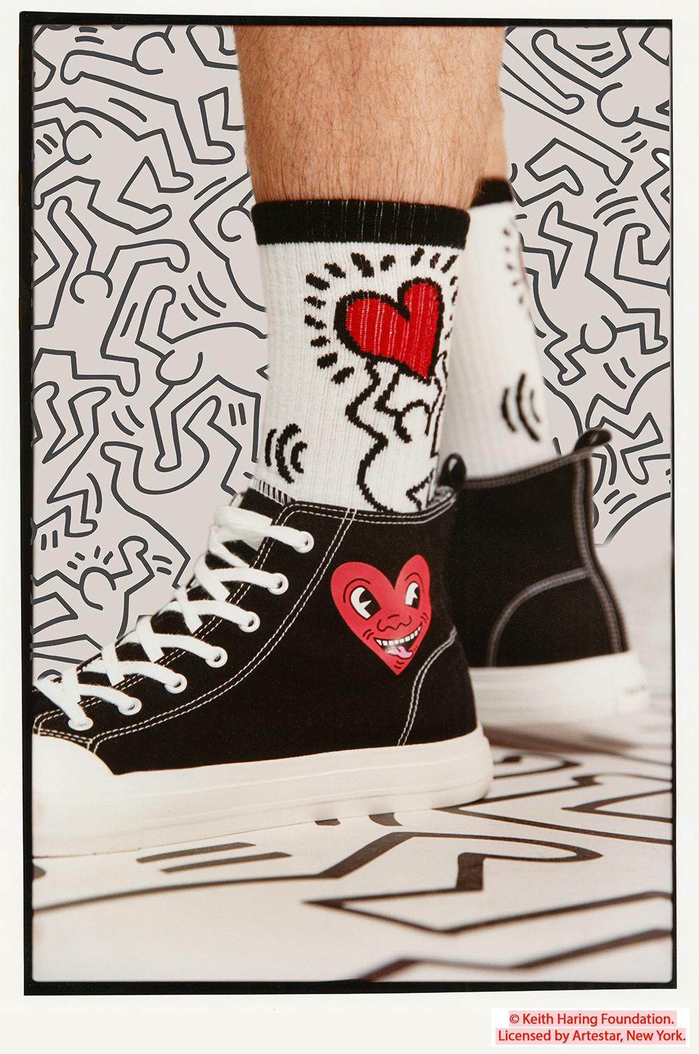 Model wears black Keith Haring high tops