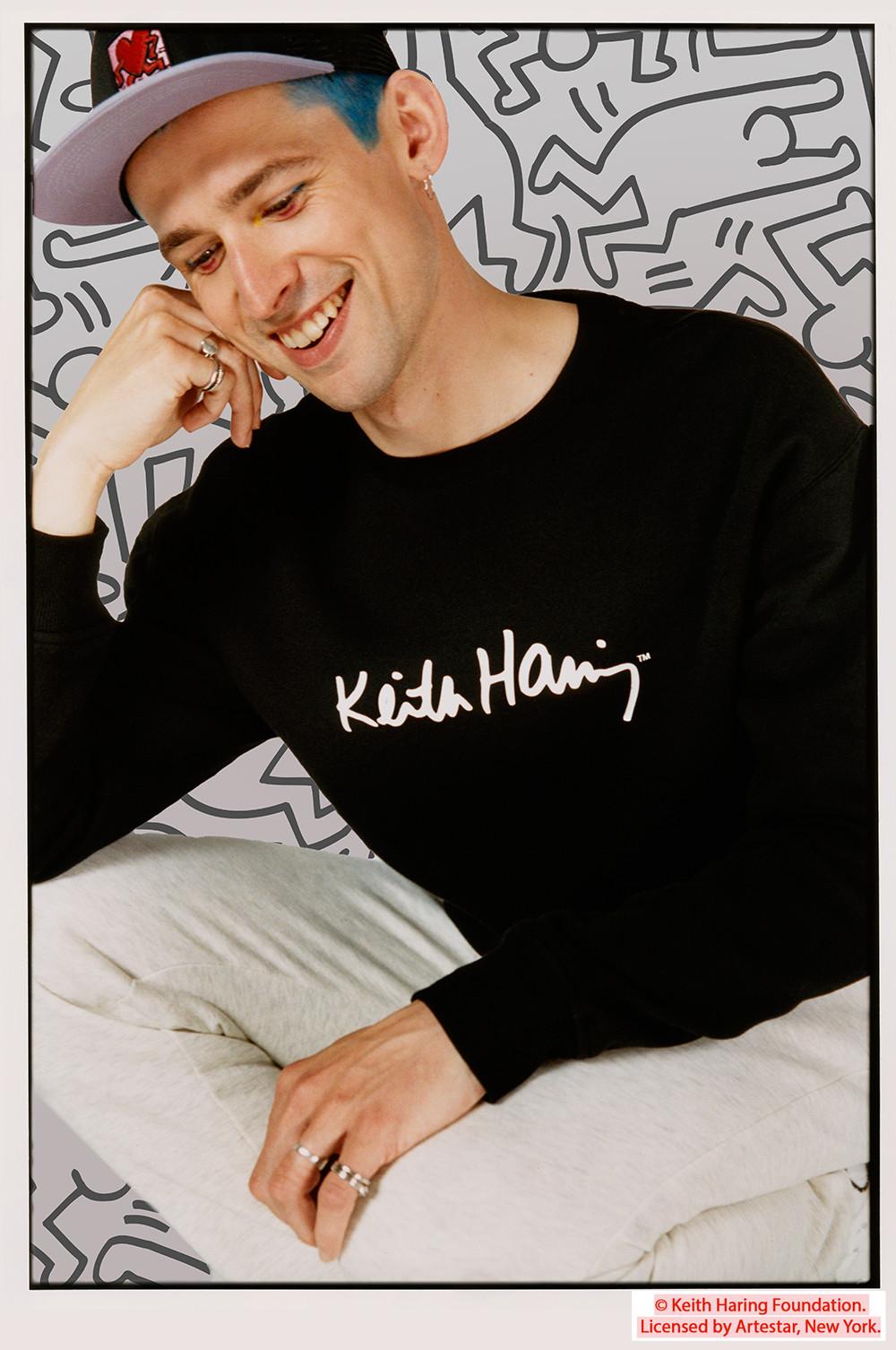 Model trägt schwarzes Keith Haring T-Shirt und Cap