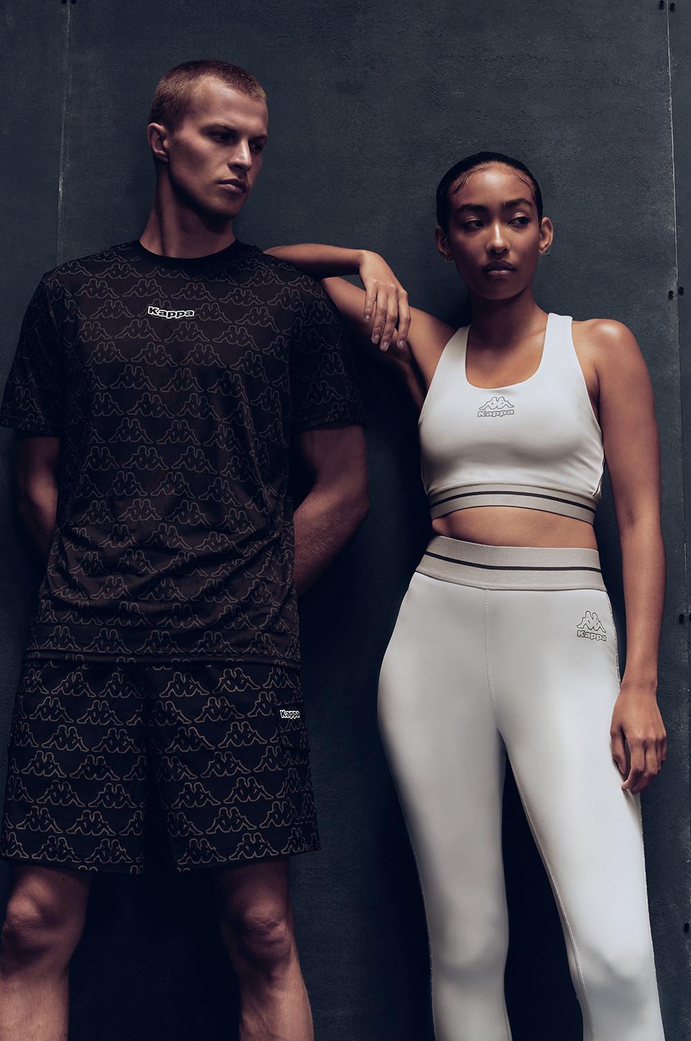 Due modelli indossano la collezione di abbigliamento sportivo Kappa x Primark composta da una maglietta scura, un top corto bianco e leggings.