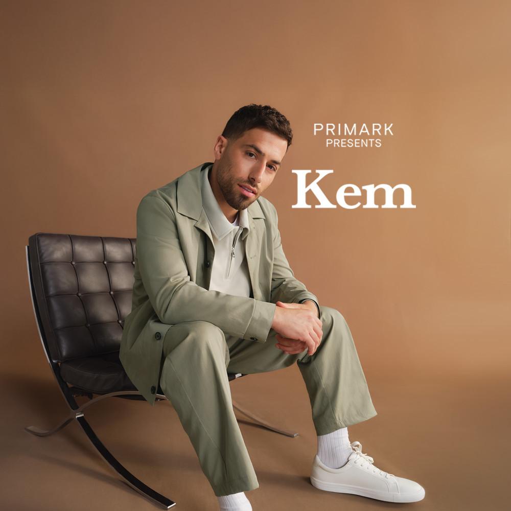 Personne vêtue d'un ensemble vert sauge Primark, porté avec des baskets blanches, assise dans un fauteuil en cuir noir.