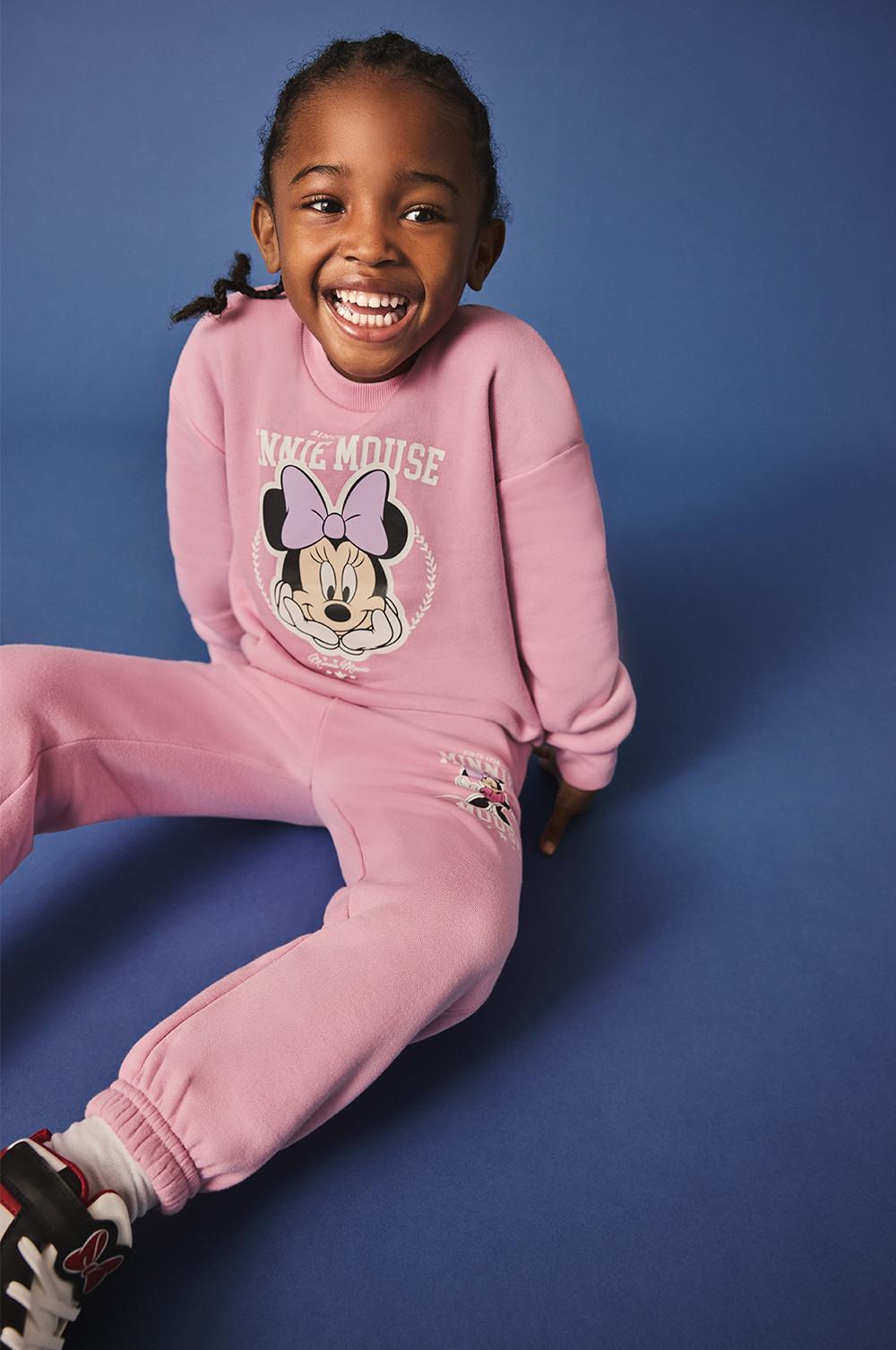 Bambina che indossa felpa e pantaloni da tuta rosa