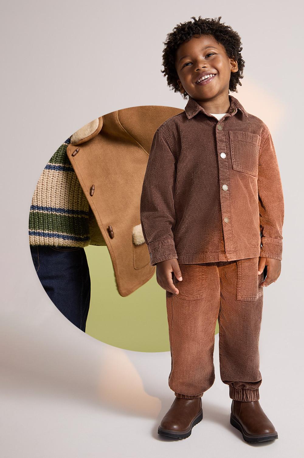 Child wearing brown corduroy outfit with matching shirt and trousers, standing next to a tan jacket with striped lining.