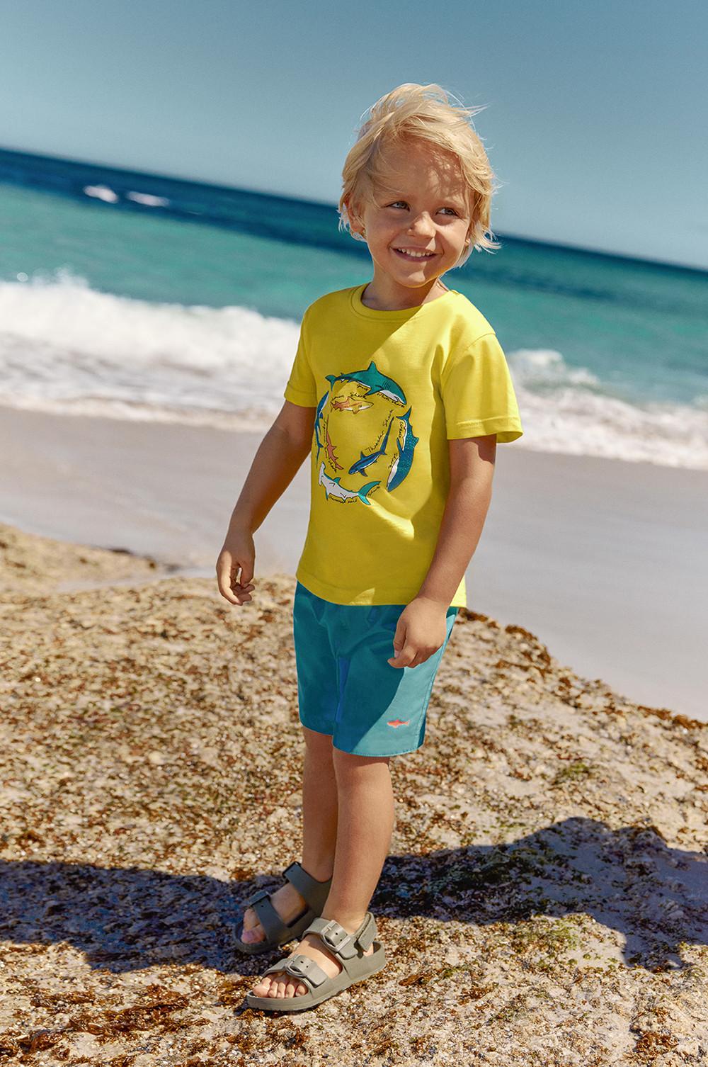 Child wears swim shorts and sandals
