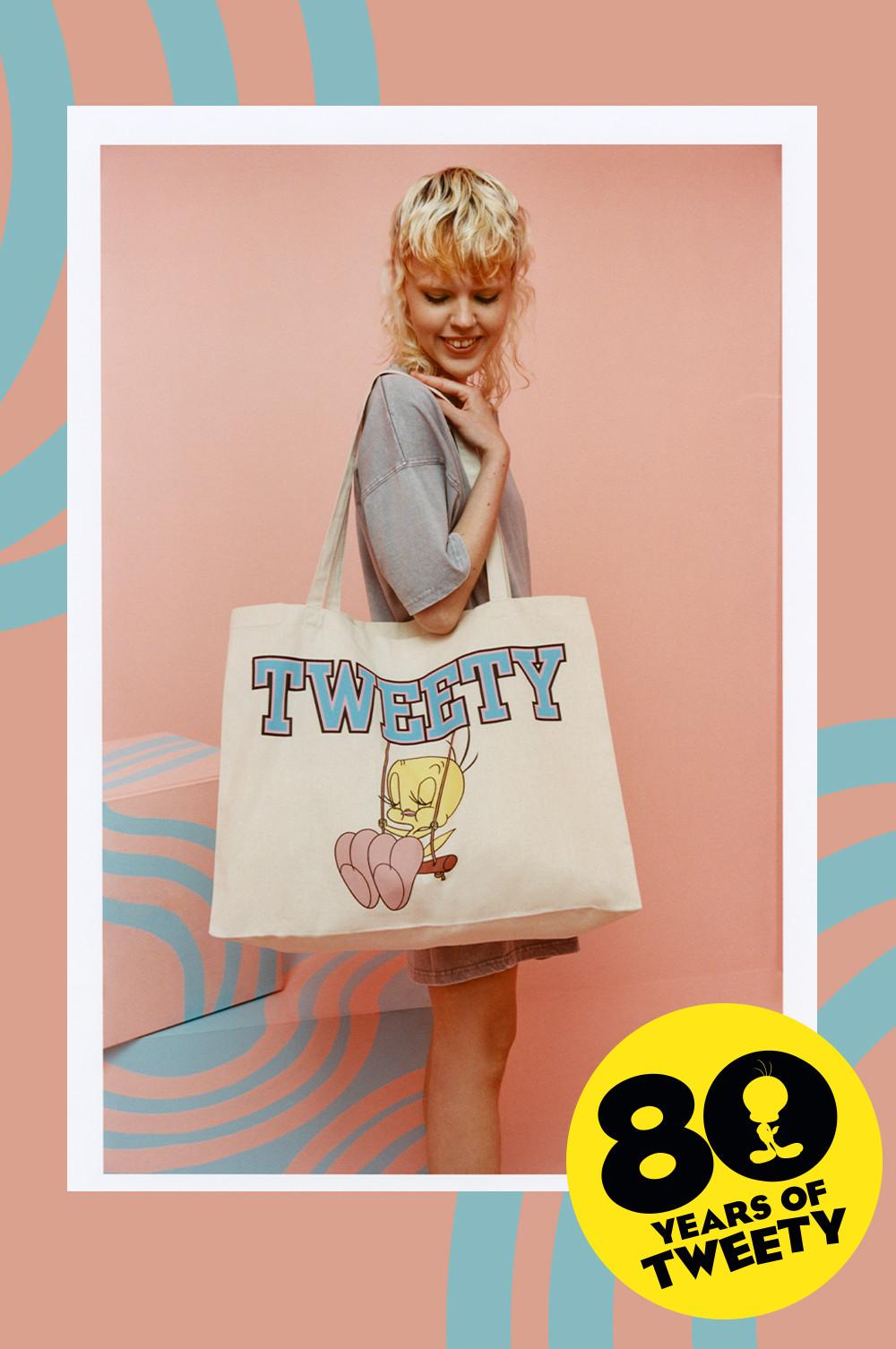 Model in grauem T-Shirt-Kleid und Canvas-Shopper