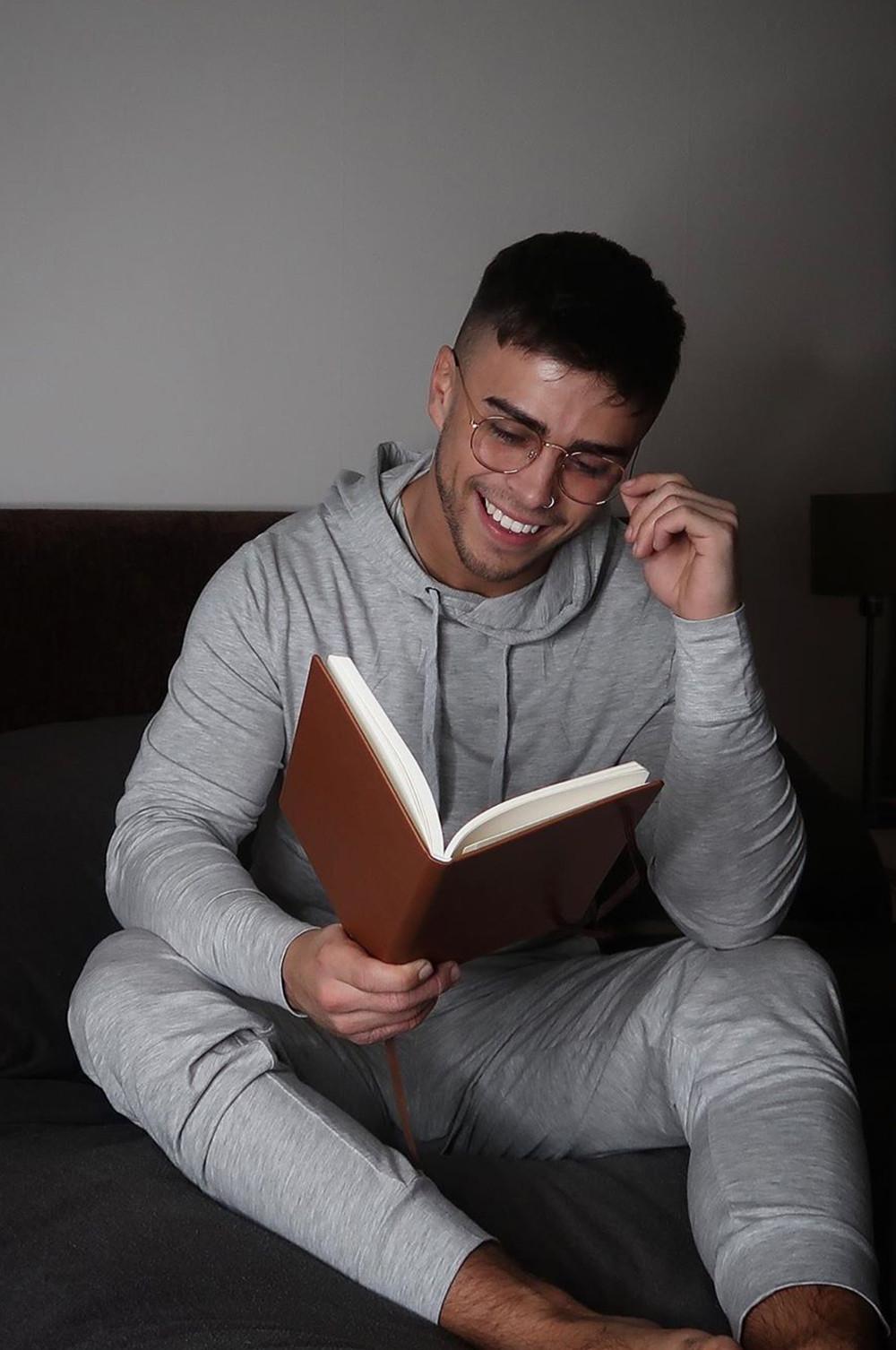 Mann in grauem Primark Trainingsanzug liest ein Buch