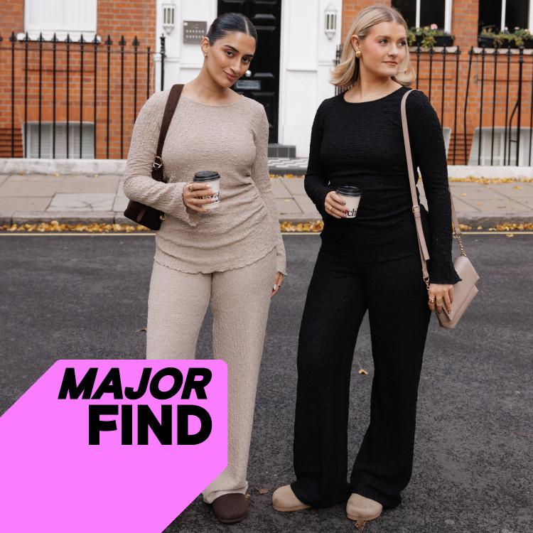 Two women walking with coffee cups, wearing coordinating beige and black loungewear sets with shoulder bags.