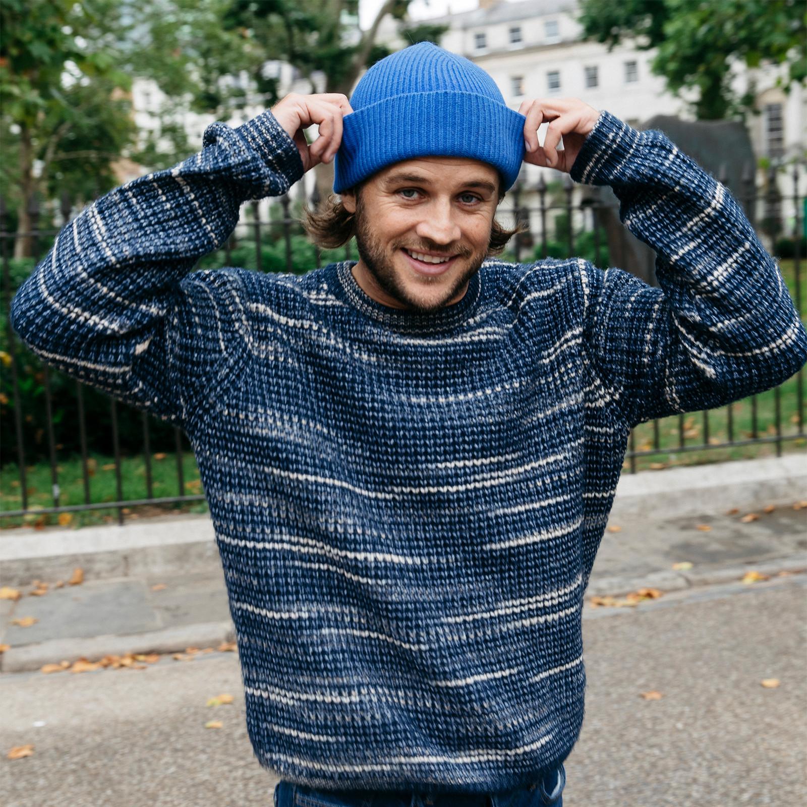 model wears blue jumper and beanie