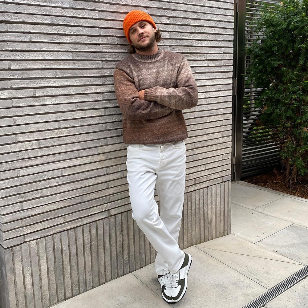 model wears brown jumper with orange beanie