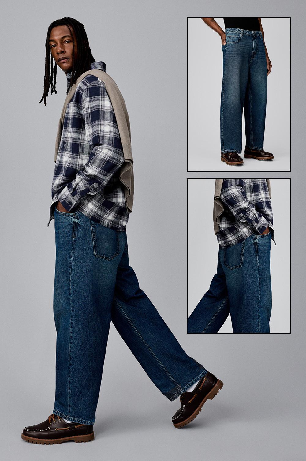 Personne portant une chemise à carreaux bleu marine sur un jean baggy avec un haut beige sur l'épaule et des chaussures bateau marron. Gros plans des détails du jean.