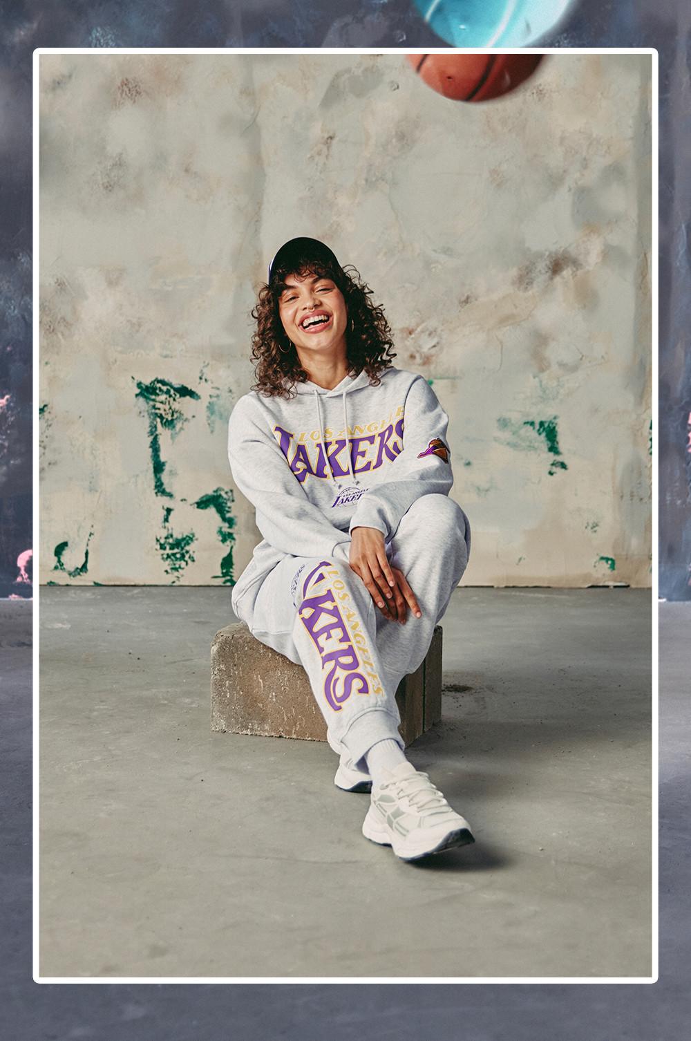 Modelo veste fato de treino e boné Lakers