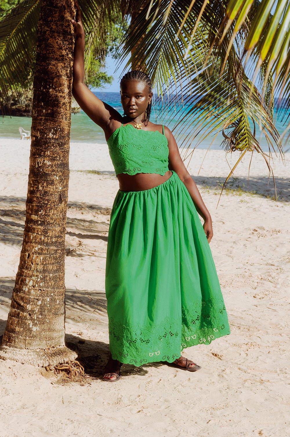 Modelo con conjunto verde bordado a juego con falda larga.