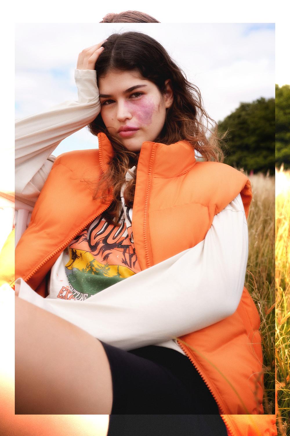 Model wears orange padded gilet