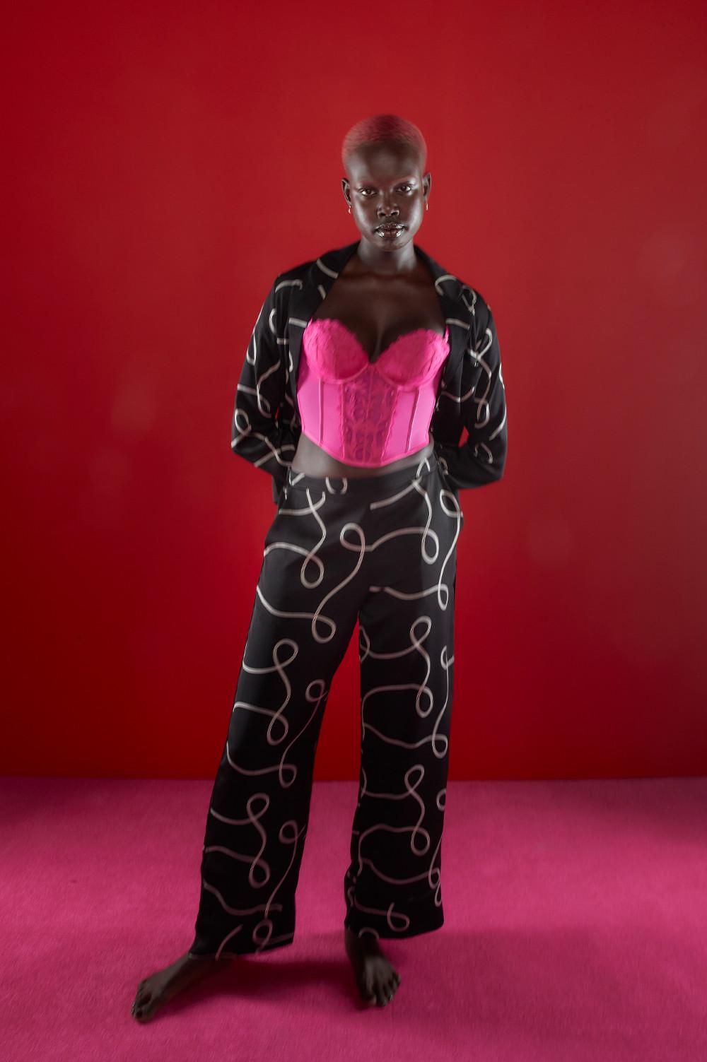 Model wears pink corset, paired with black and white swirl print pyjamas