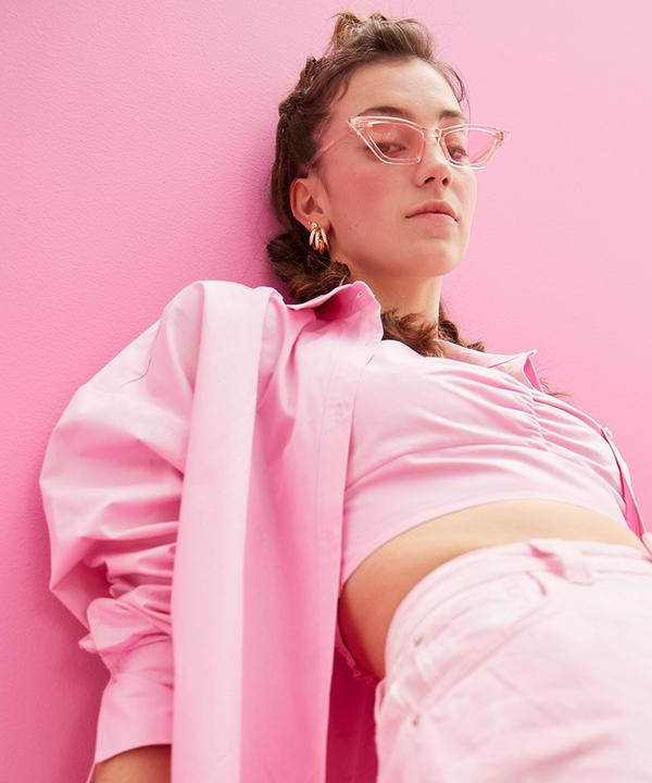 Model wearing pink outfit, jacket and glasses