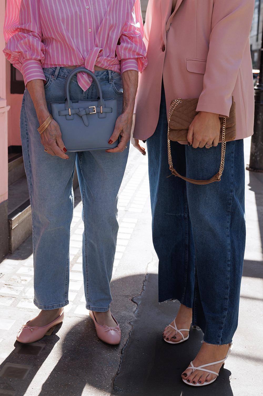 Models wearing a pink striped shirt, blue jeans, pink ballet flats and blue bag, the other, pink blazer, brown bag, blue jeans and heels