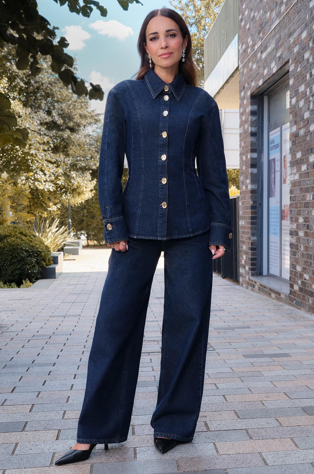 Dark denim outfit featuring fitted shirt jacket with decorative buttons and wide-leg trousers, paired with black pointed heels.