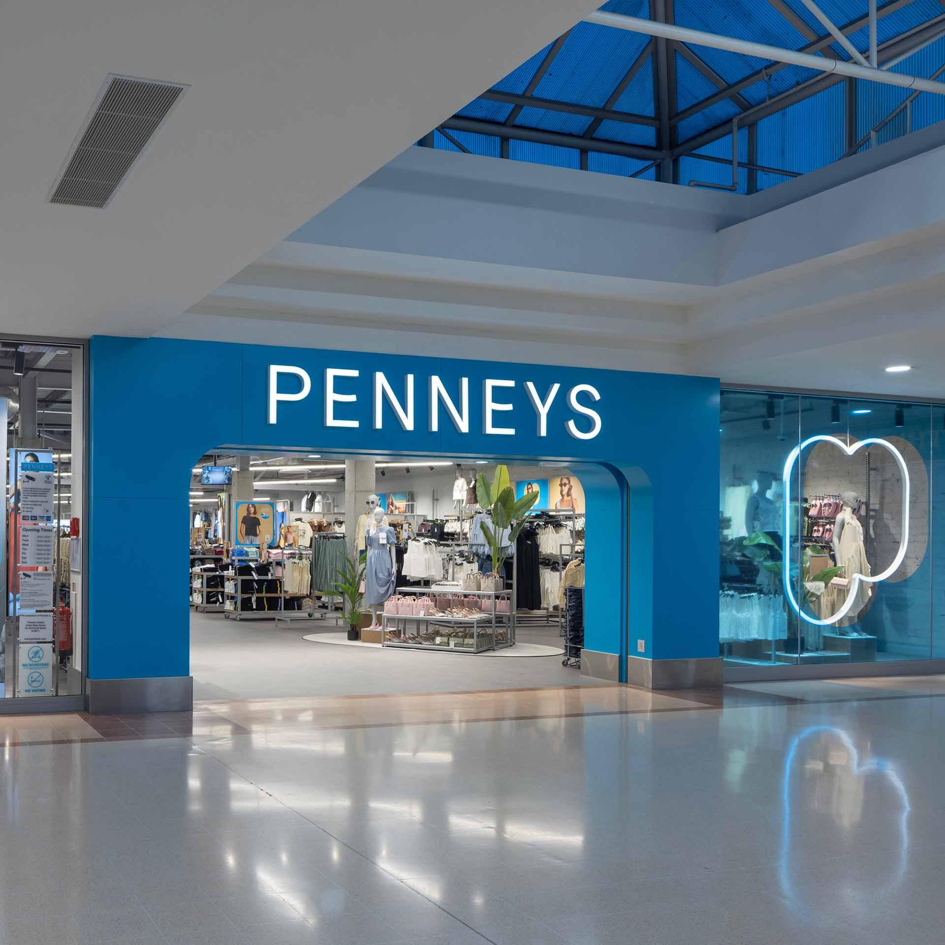 Store entrance with a blue facade, displaying "Penneys" in bold, white letters.