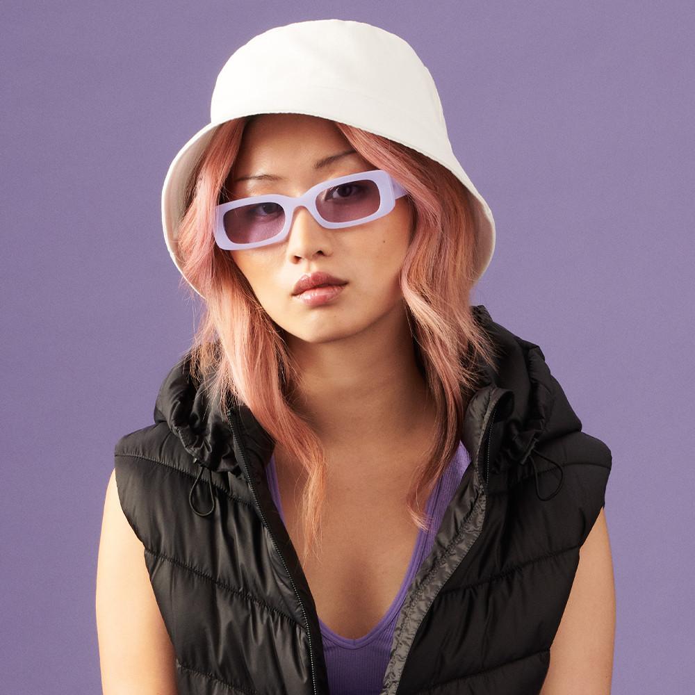 Model wears white bucket hat and lilac glasses