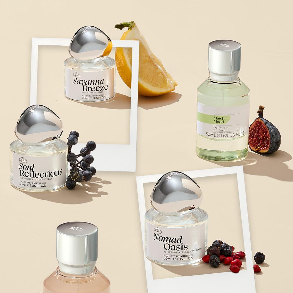 Collection of PRO perfumes with distinctive bottles displayed alongside fruits and berries that complement each fragrance's notes.