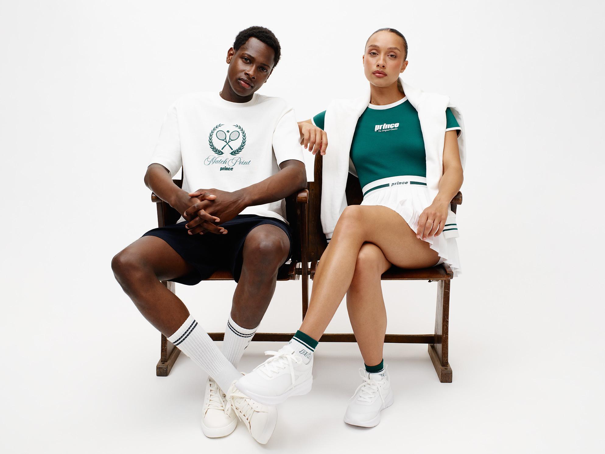 A man and woman pose in stylish tennis apparel, showcasing a modern athletic look.