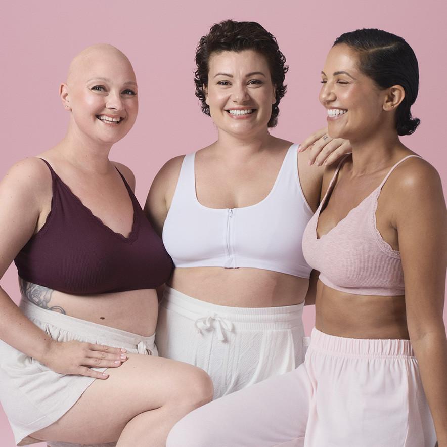 Three women smiling and wearing Primark's Breast Cancer Awareness collection