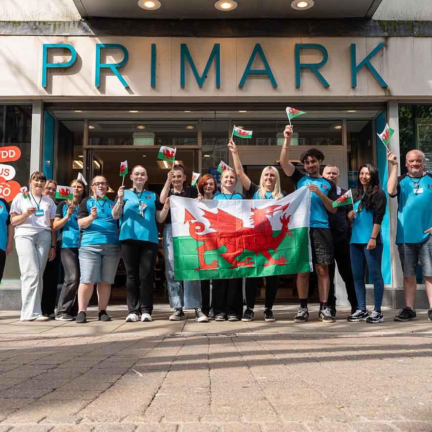 Primark colleagues standing outside store with Welsh flag