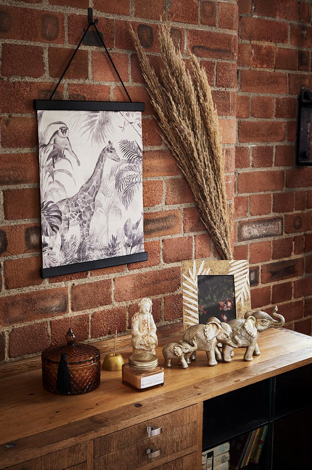 Sala de estar con lienzo decorativo para la pared, adornos y marco de fotos