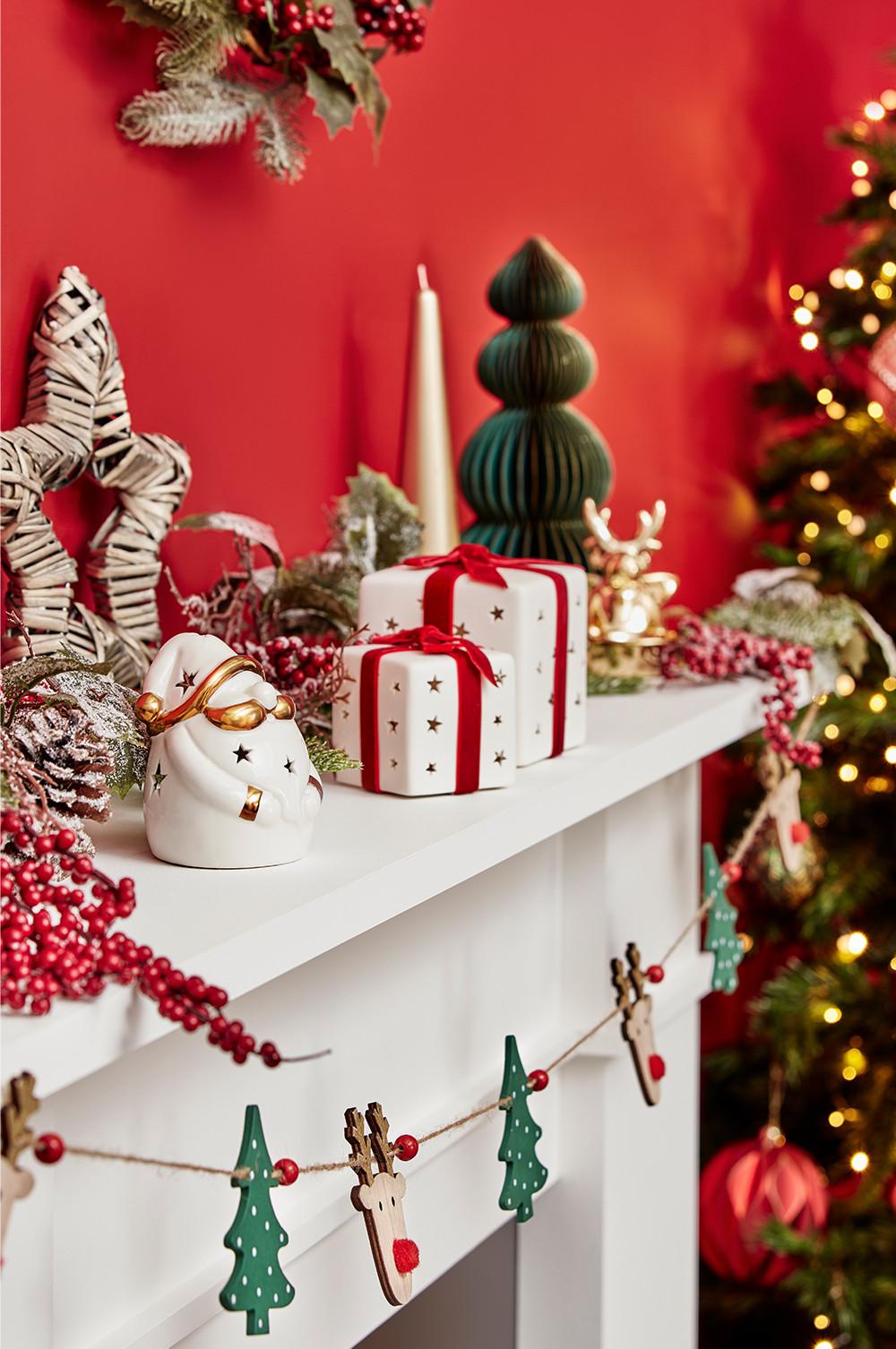 Caminetto decorato con candele natalizie