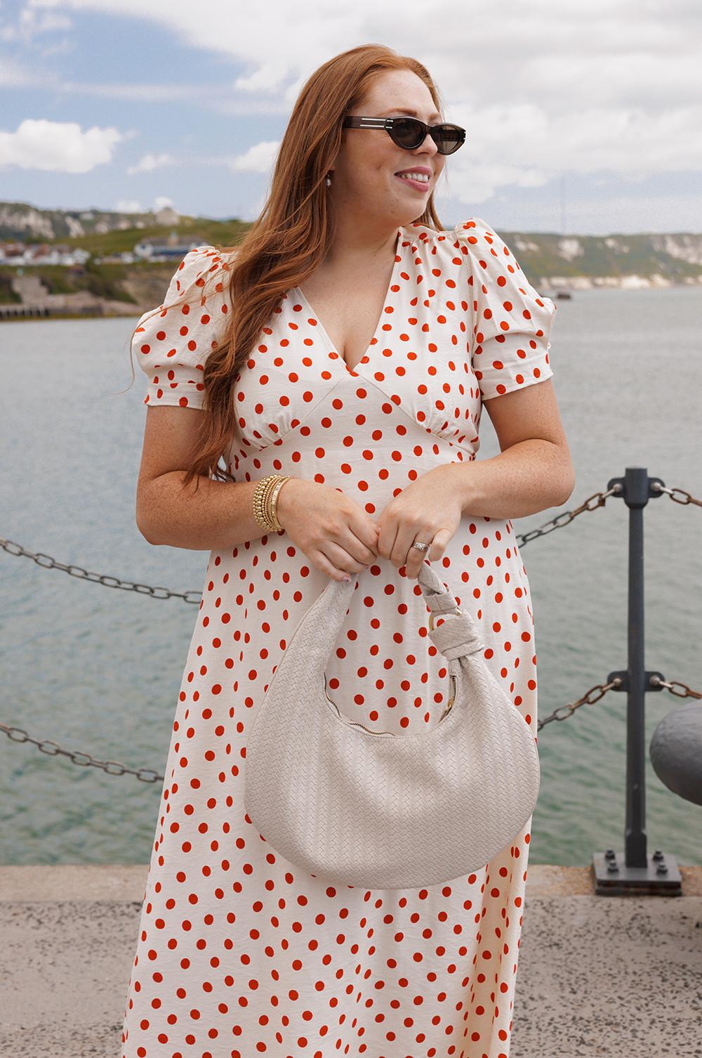 Model wears midi dress in red and white polka dot