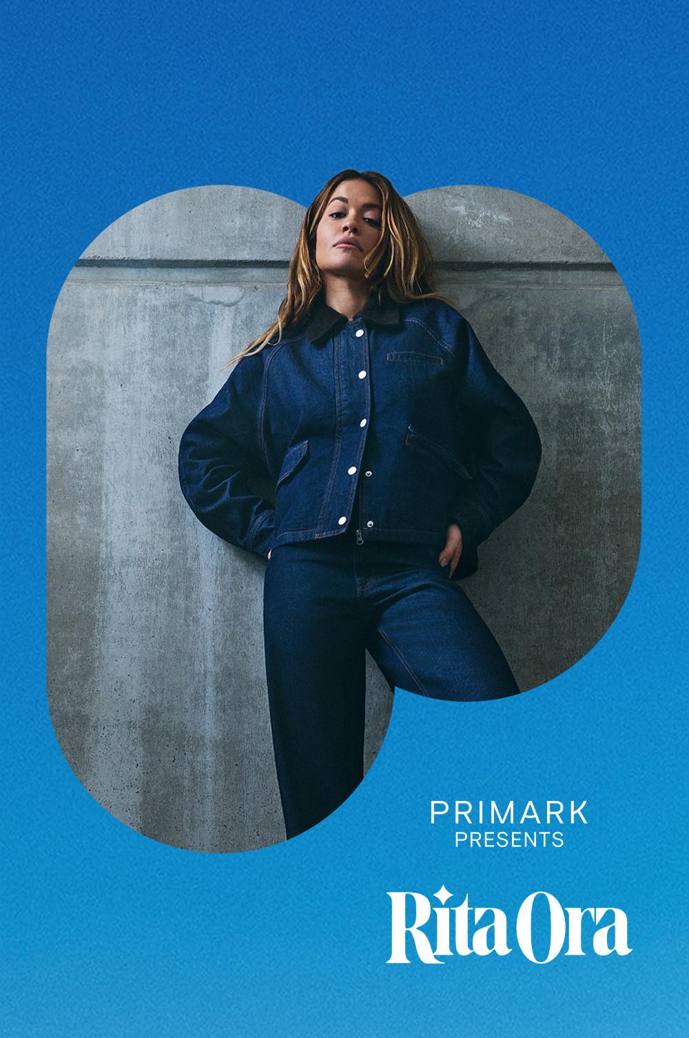 Model in schwarzer Jeansjacke und Jeans vor einem Hintergrund aus Beton, aus der Kollektion Primark präsentiert Rita Ora.