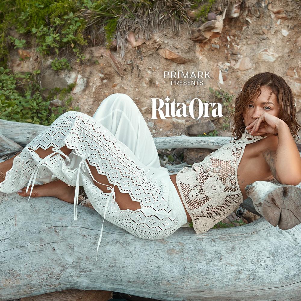 Rita Ora má na sebe biely háčkovaný top, nohavice s výšivkami a viazanými detailmi