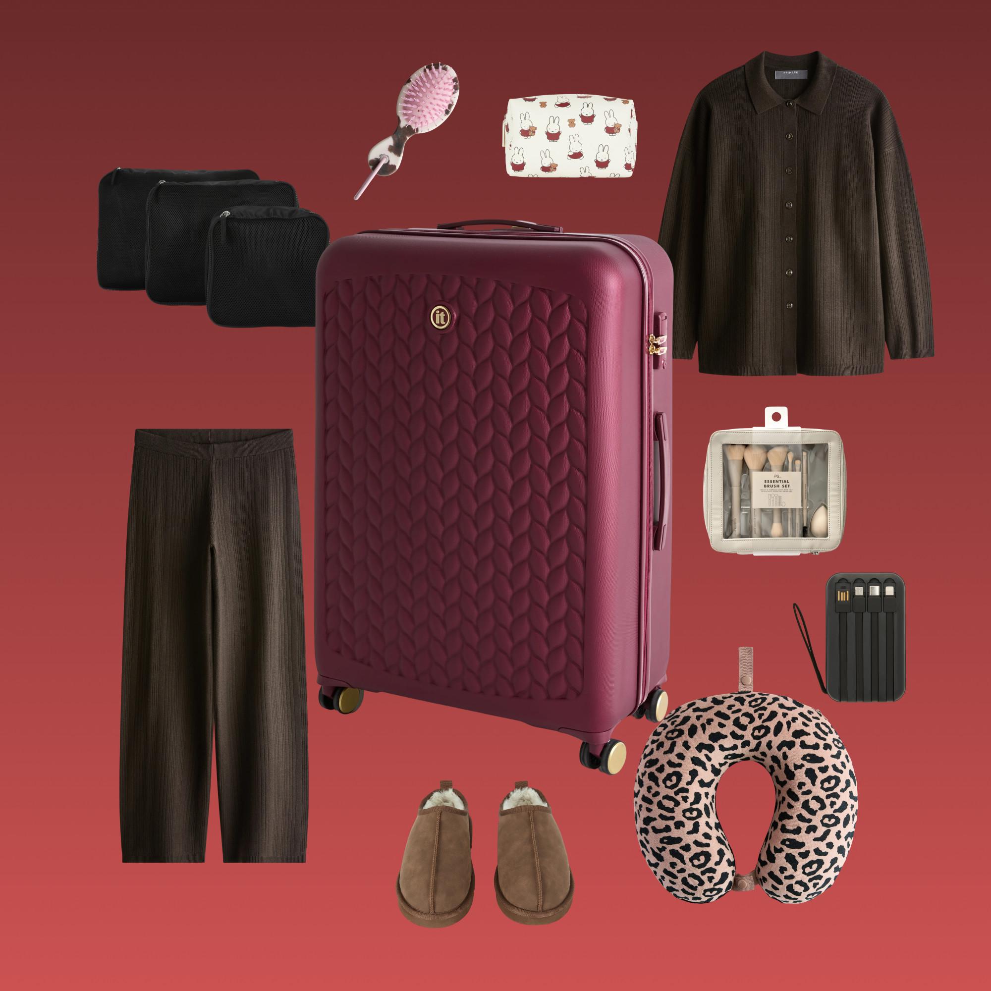 Burgundy suitcase surrounded by travel essentials including clothing, slippers, neck pillow and toiletry bags.