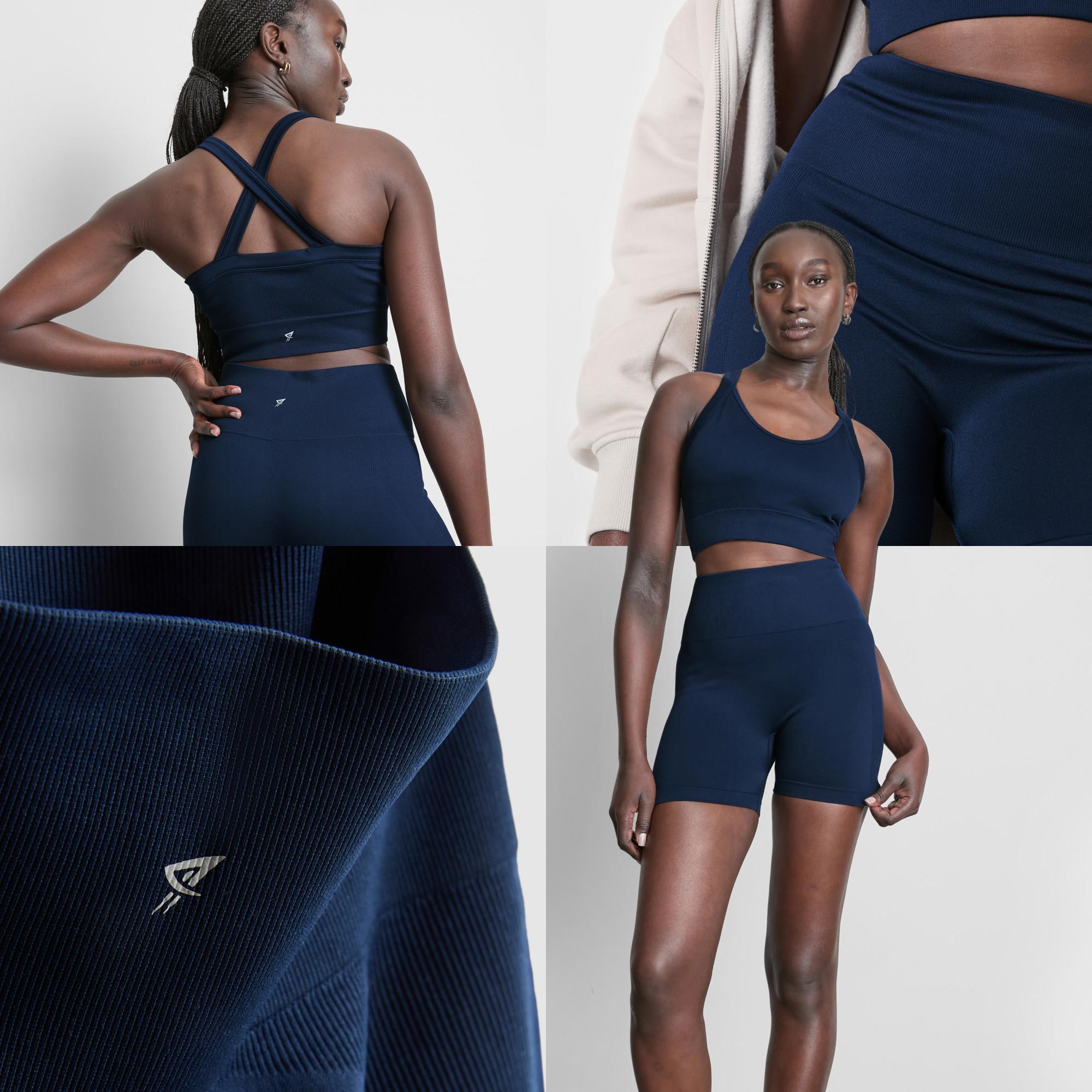 Navy blue activewear set featuring cross-back sports bra and high-waisted shorts with ribbed fabric detail.