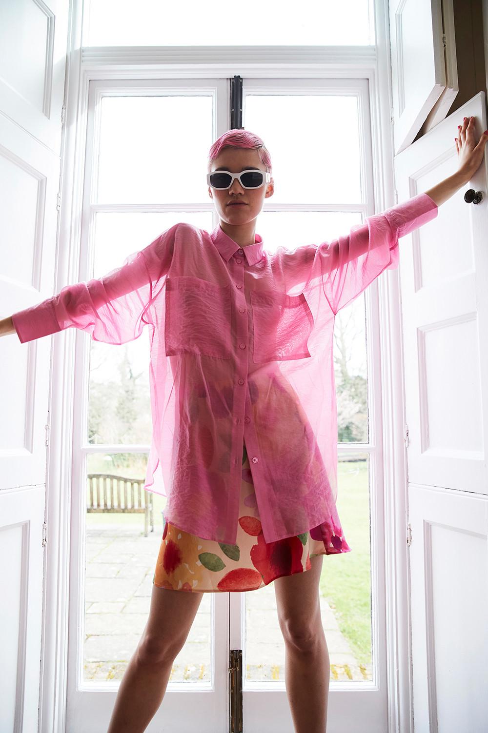 Model wearing pink shirt and floral dress