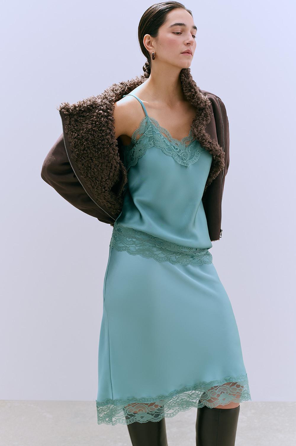Mint green slip dress with lace trim, paired with brown shearling jacket and dark boots.