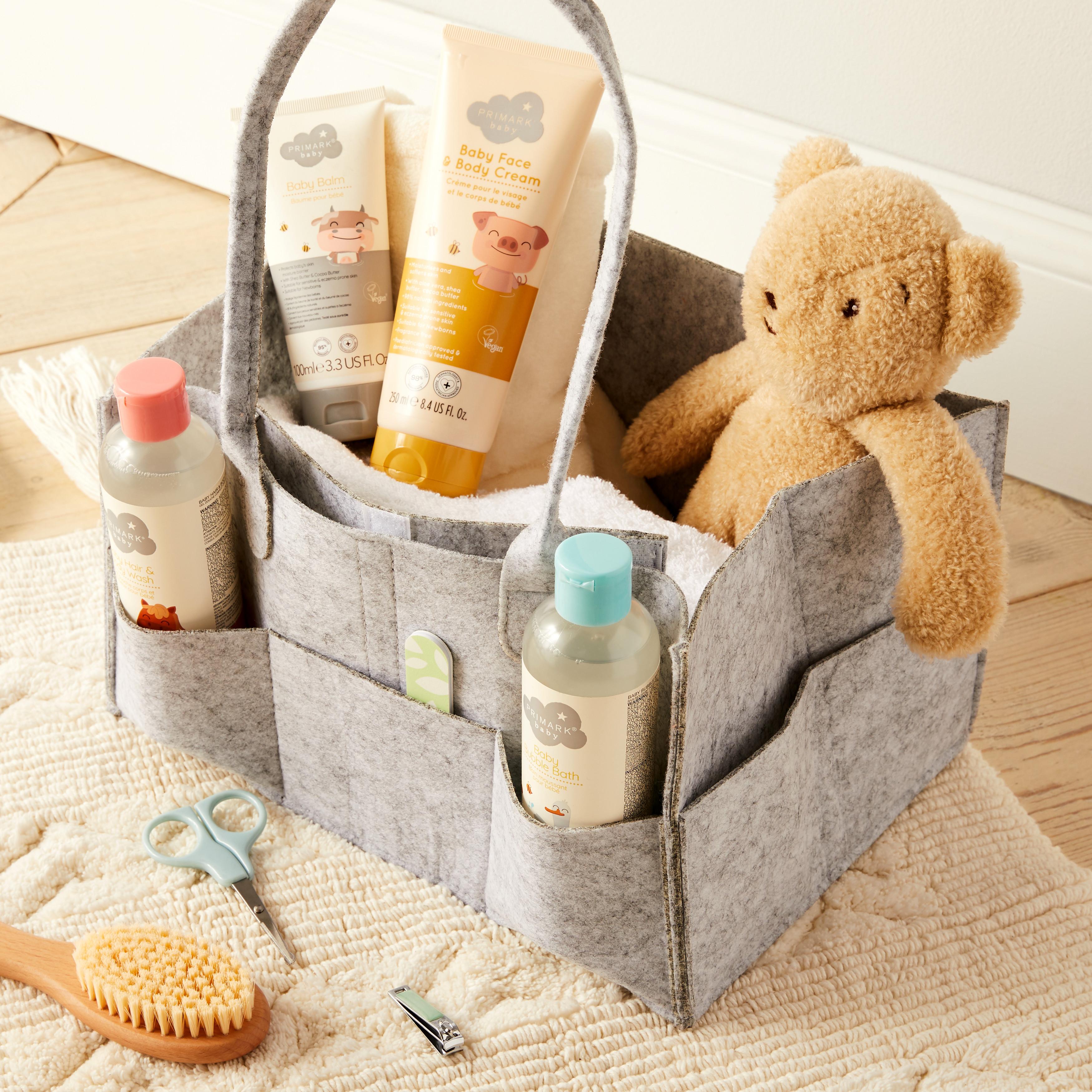 Grey Basket containing Primark Baby products and teddy bear