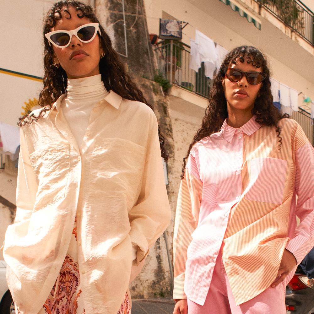 Women wearing coloured shirts, patterned trousers and pink trousers