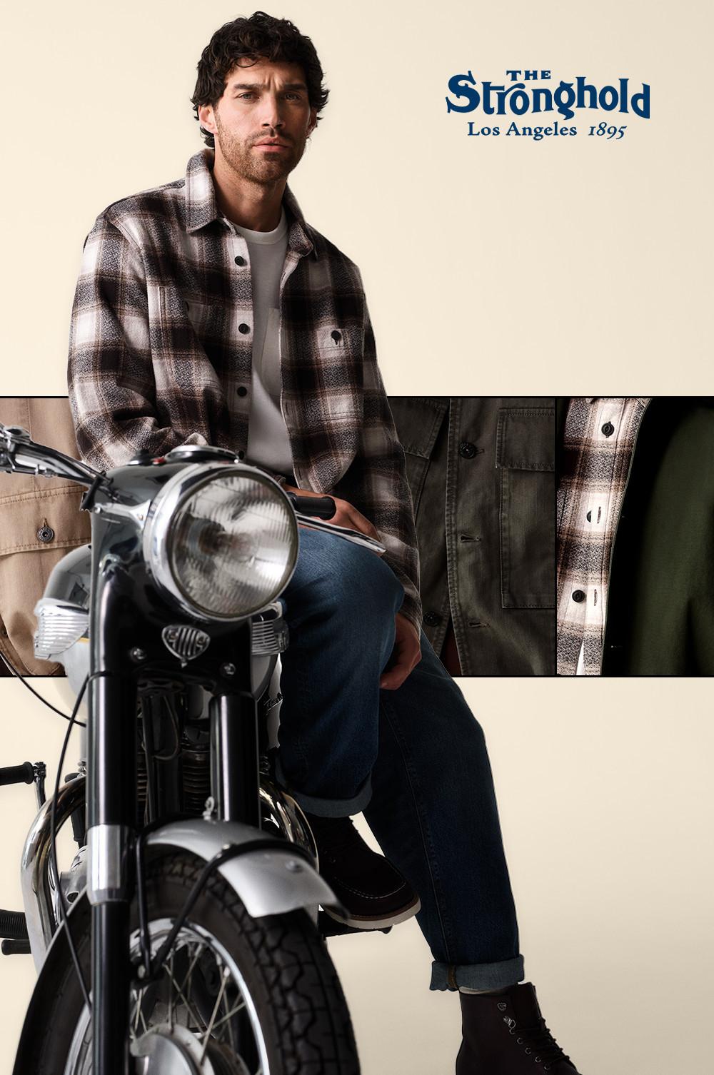 Persona seduta su una moto vintage che indossa una camicia con motivo scozzese bianco e nero, una T-shirt bianca e jeans. Con logo The Stronghold Los Angeles 1895.