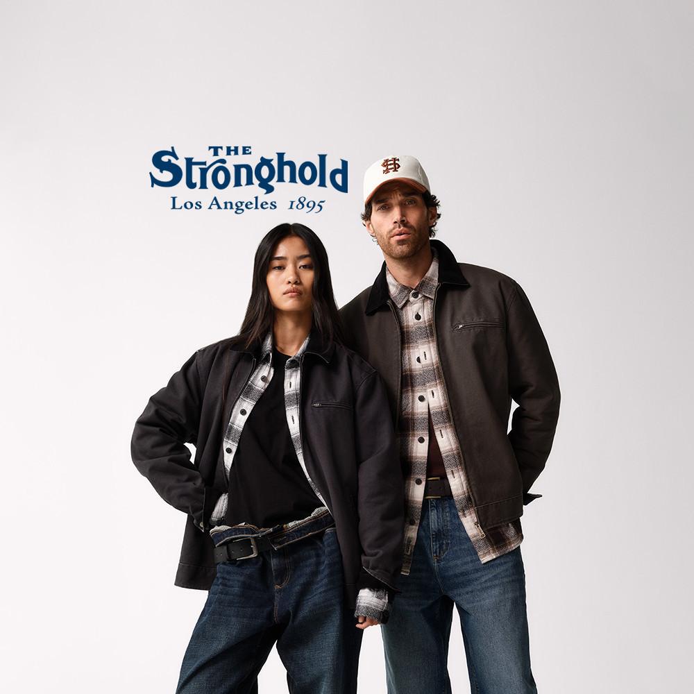 Due modelli che indossano giacche con logo The Stronghold Los Angeles, camicie con motivo scozzese e jeans.