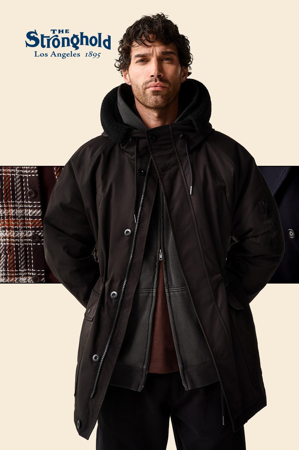 Person wearing a black winter coat with hood from The Stronghold Los Angeles 1895 collection.