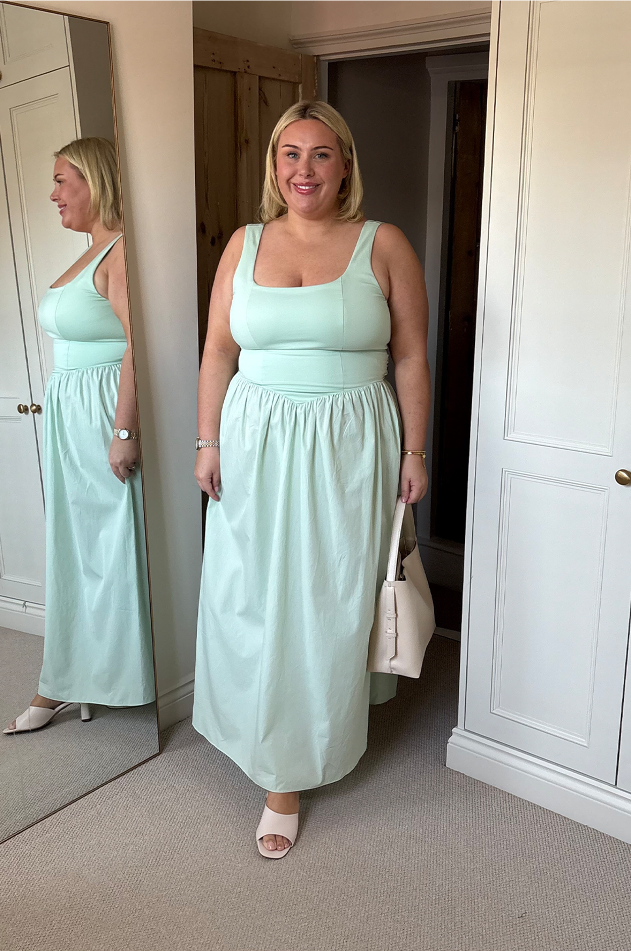 Model wears midi pastel green corset dress with white sandals and white bag.