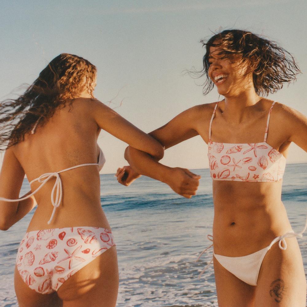 Models wear shell print bikinis