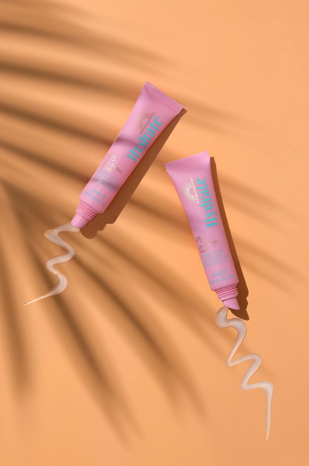 Due tubetti rosa di maschera per labbra con spirali di crema accanto. Si legge la scritta "hydrate".