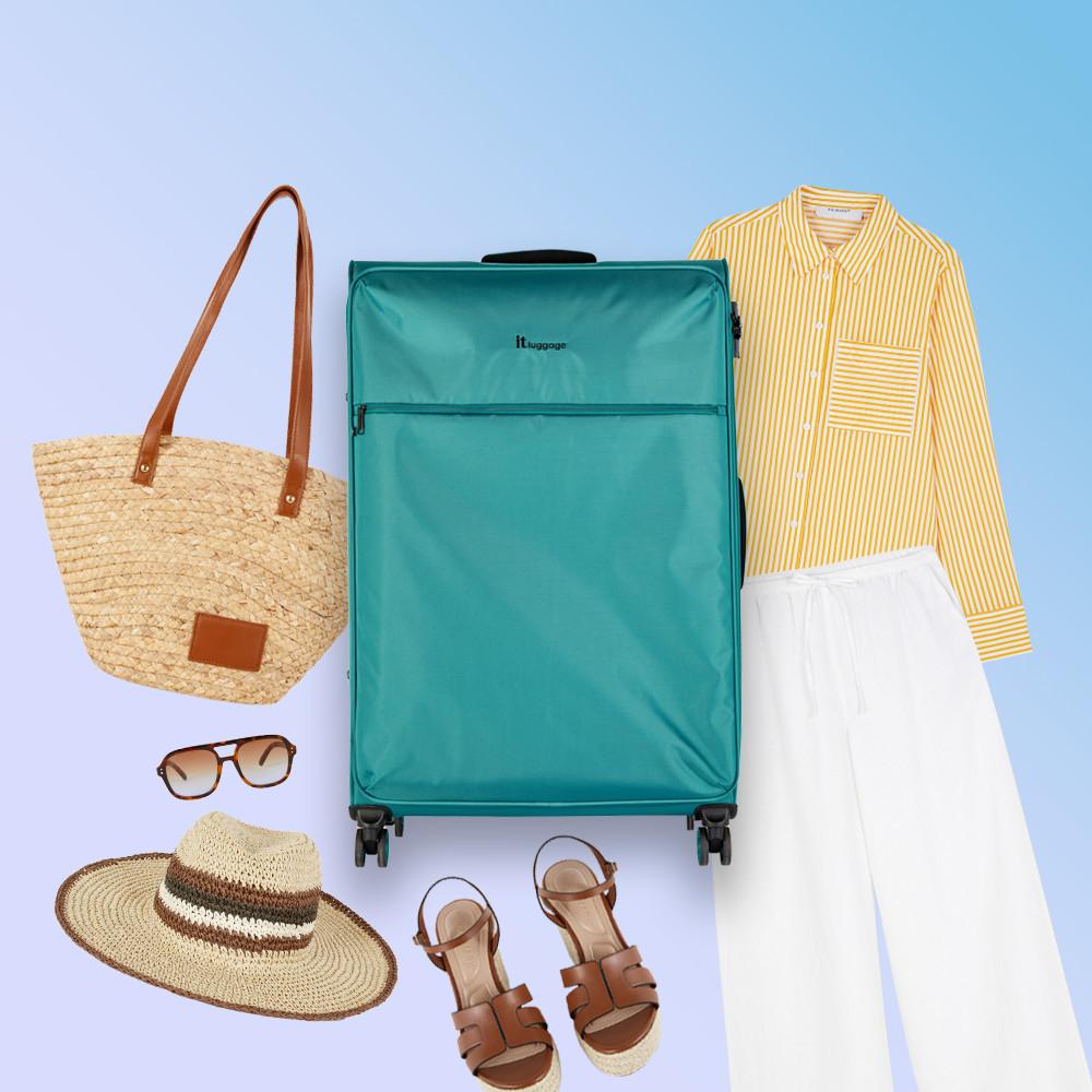 Valigia it Luggage ottanio circondata da articoli indispensabili per le vacanze, tra cui cappello di paglia, occhiali da sole, borsa da spiaggia intrecciata, camicia a righe gialle, pantaloni bianchi e sandali marroni.
