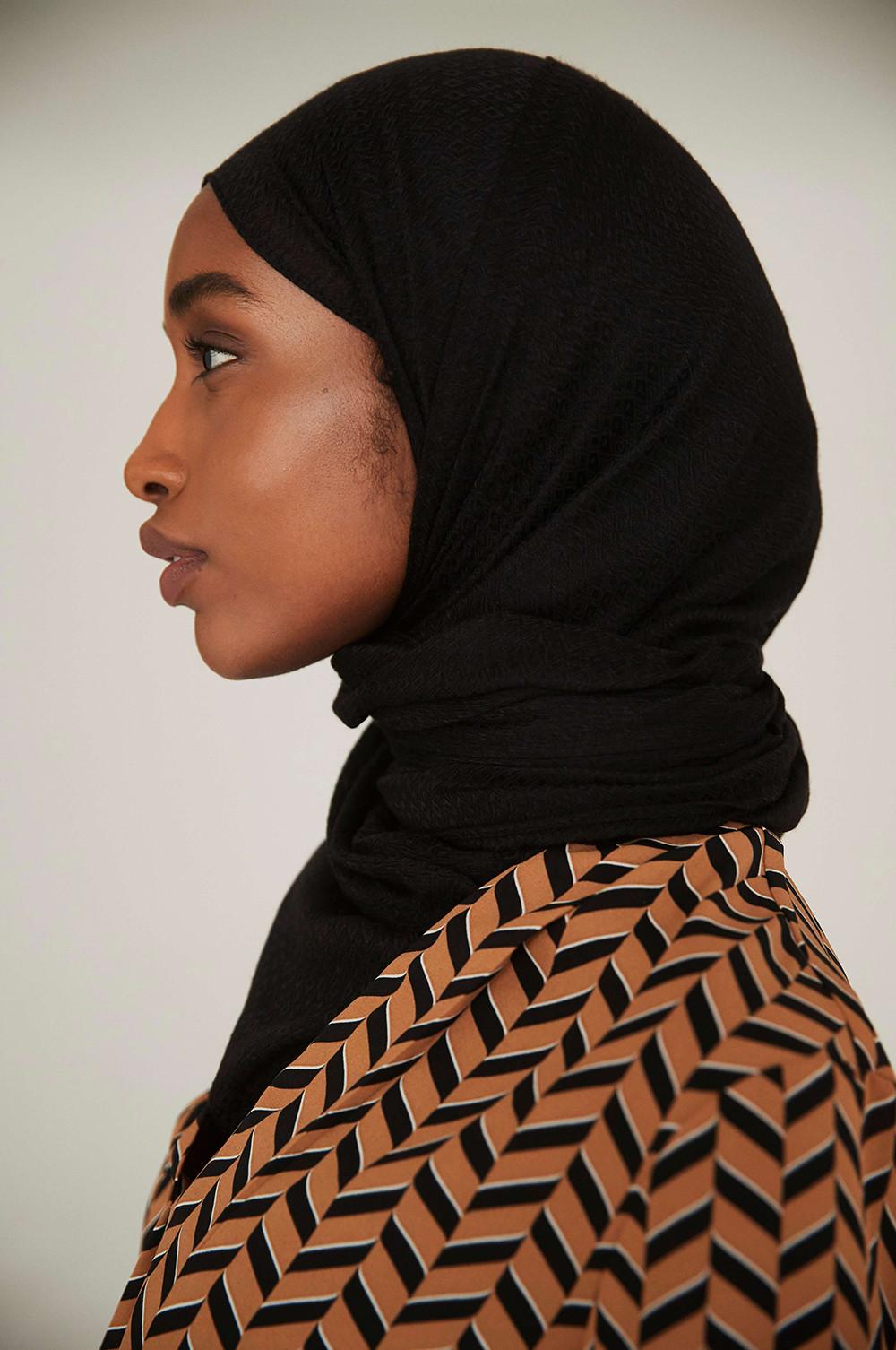 Model wearing dark head scarf