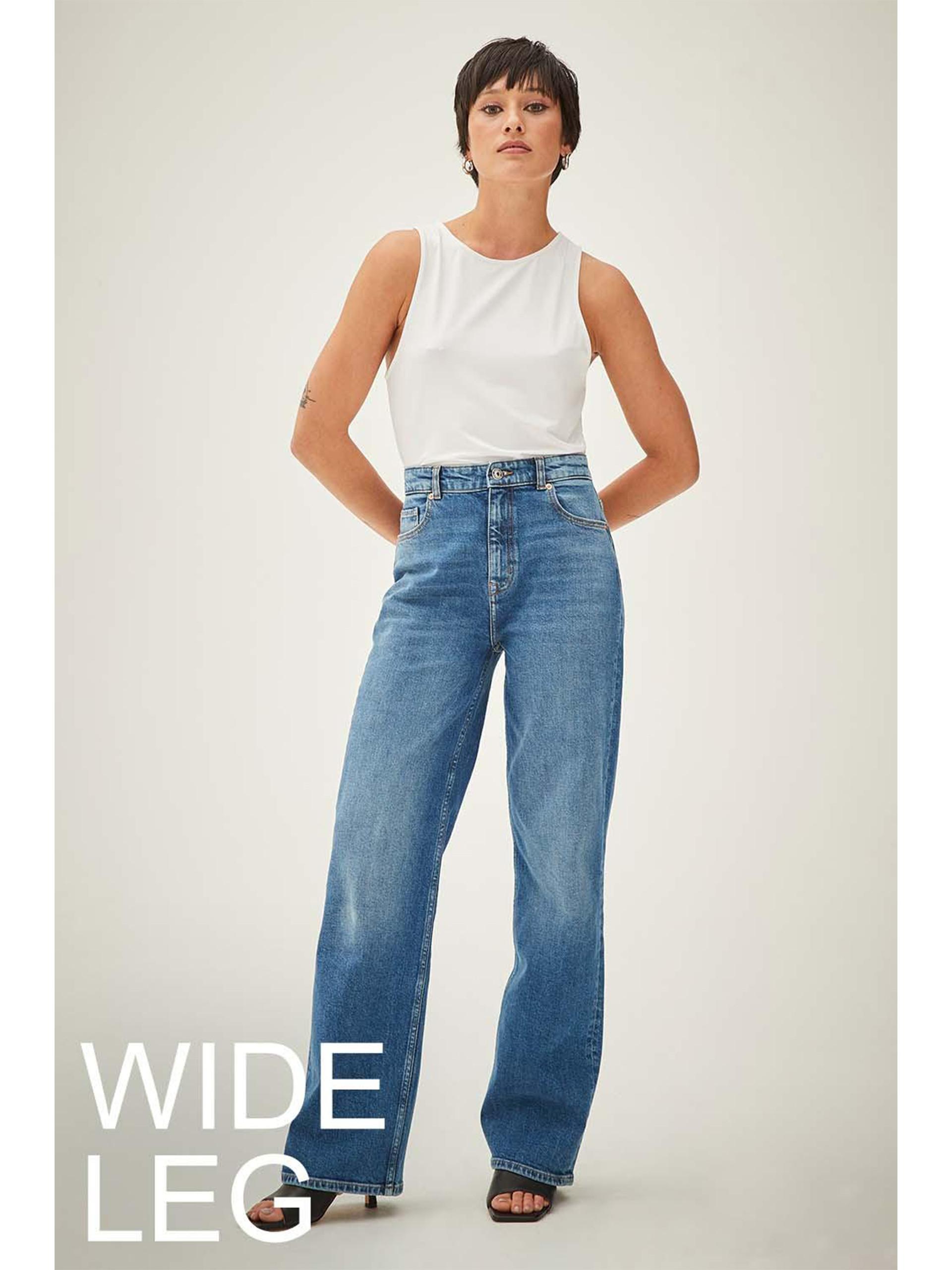 Model wears blue wide leg jeans