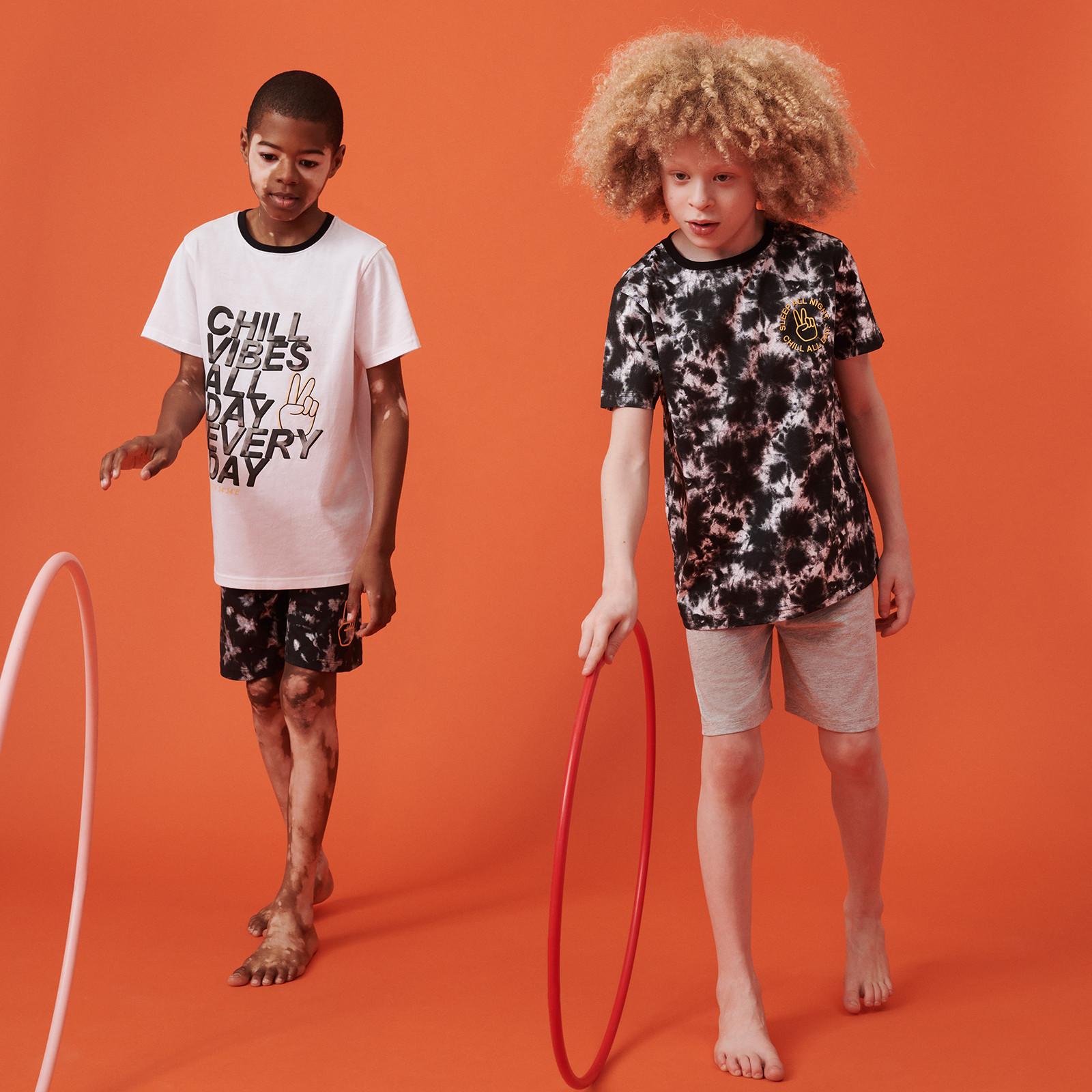 Bambini con hula hoop che indossano shorts e t-shirt a fantasia