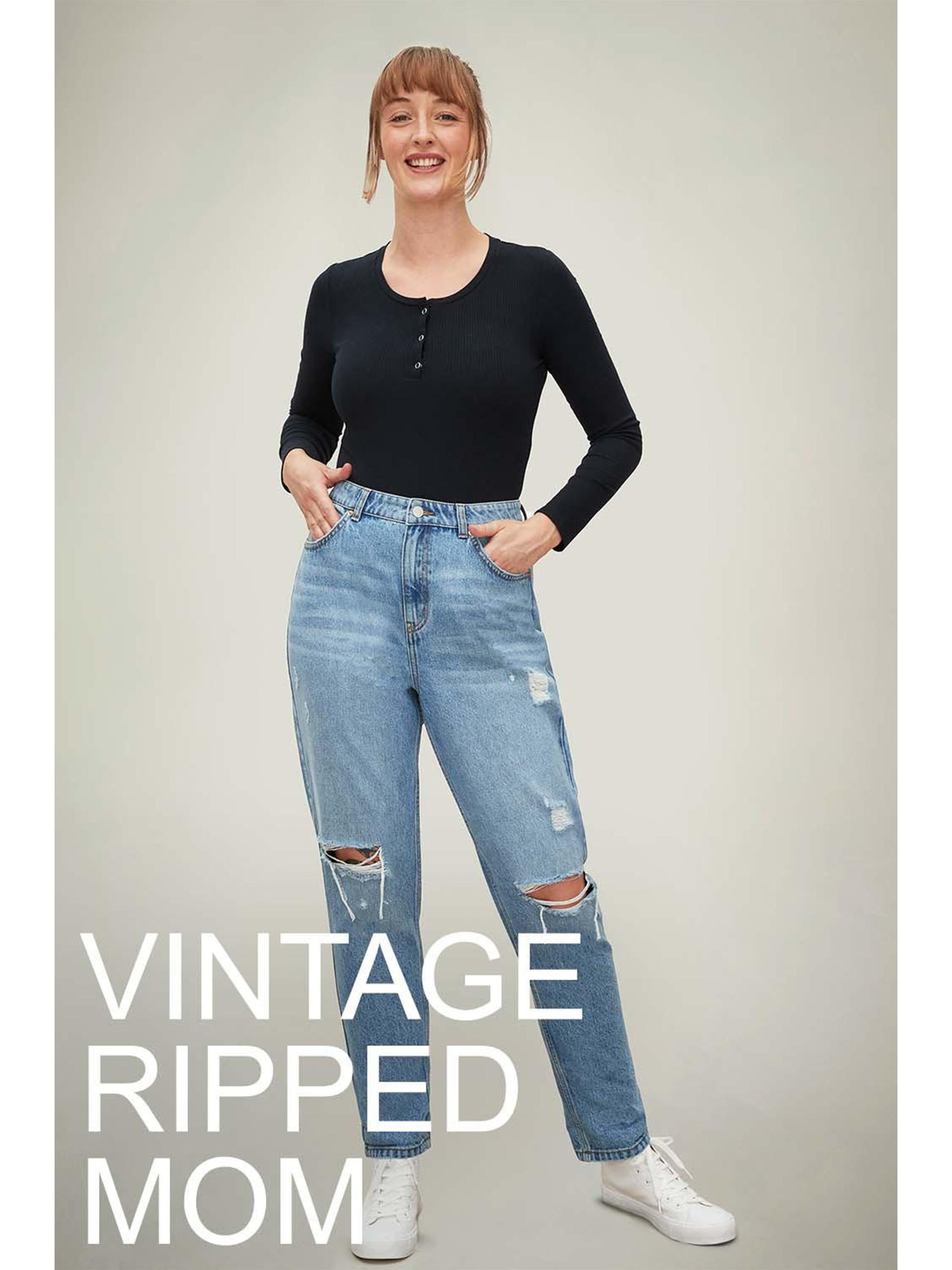 Model wears ripped vintage mom jeans